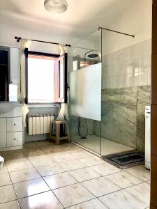 bagno con doccia in vetro e finestra di Casa La Vigna a Puntalazzo