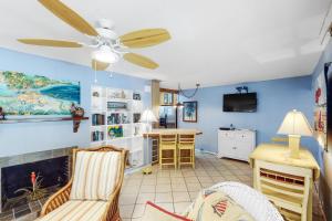 a living room with a fireplace and a ceiling fan at 21 Palms in Anna Maria