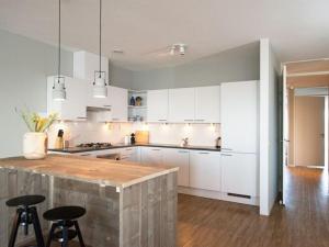 une cuisine avec des placards blancs et un comptoir en bois dans l'établissement Luxury apartment near Scheveningen beach, à Scheveningen