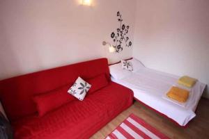 uma sala de estar com um sofá vermelho e uma cama em Apartment in Crikvenica 14218 em Crikvenica