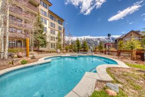 una piscina frente a un edificio con montaña en Passage Point 521, en Frisco