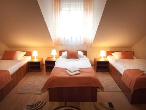 a bedroom with two beds and a window with two lamps at Hotel Ostoja in Bobowa
