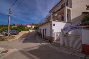 a building with a car parked on a street at Apartment in Vrbnik/Island Krk 35825 in Vrbnik