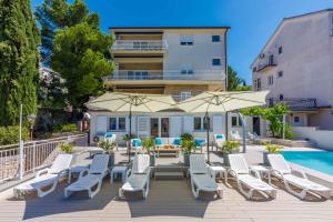 eine Terrasse mit Stühlen und Sonnenschirmen neben einem Pool in der Unterkunft Apartment in Crikvenica 34976 in Crikvenica