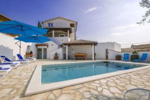 basen przed domem z niebieskimi parasolami w obiekcie Holiday home in Porec 35381 w mieście Dračevac