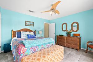 a bedroom with a bed and a dresser and two mirrors at Seas the Day in Navarre