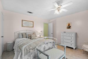 a bedroom with a bed with a ceiling fan and a chair at Sunny Daze in Navarre
