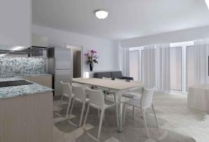 een keuken en eetkamer met een tafel en stoelen bij Apartments in Lignano Sabbiadoro 31391 in Lignano Sabbiadoro