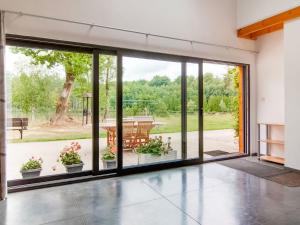 uma sala de estar aberta com grandes portas de vidro deslizantes em Premium Cottage in Florennes near Private Fish Lake Forest em Florennes