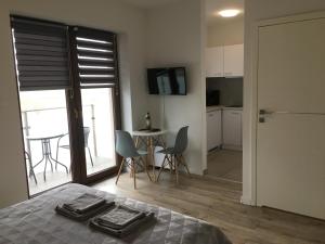 a bedroom with a bed and a kitchen with a table and chairs at Studio Fibra Barista in Rybnik