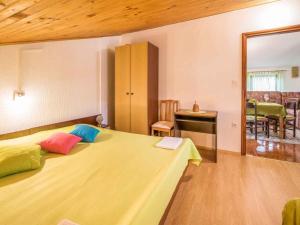 a bedroom with a bed with colorful pillows on it at Apartment in Vrbnik - Insel Krk 13622 in Vrbnik