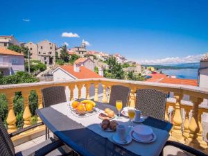 a table on a balcony with a view of the water at Apartments in Vrbnik/Insel Krk 13611 in Vrbnik