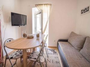 a small living room with a table and a couch at Apartments in Vrbnik/Insel Krk 13611 in Vrbnik