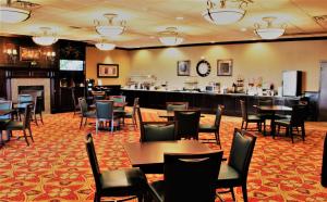 a restaurant with tables and chairs and a bar at Best Western Plus Burlington in Burlington