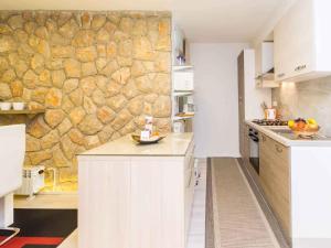 a kitchen with a stone wall in the background at Apartment in Njivice/Insel Krk 33553 in Njivice