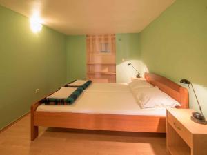 a bedroom with a large bed with green walls at Apartment in Vrbnik/Insel Krk 13614 in Vrbnik