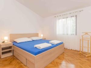 a bedroom with a bed with blue sheets and a window at Apartment in Njivice/Insel Krk 27855 in Njivice