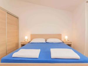 a bedroom with a blue bed with two white pillows at Apartment in Njivice/Insel Krk 27855 in Njivice