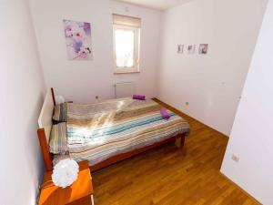 a small bedroom with a bed and a window at Apartment in Njivice/Insel Krk 27658 in Njivice