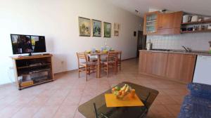 a kitchen and living room with a table and a tv at Apartment in Porat/Insel Krk 13205 in Porat