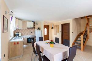 a kitchen and dining room with a table and chairs at Apartment in Porat/Insel Krk 13159 in Porat