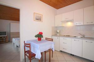 kuchnia ze stołem, na którym stoi wazon z kwiatami w obiekcie Apartment in Porec - Istrien 9922 w Poreču
