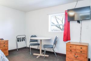 Habitación con mesa, 2 sillas y ventana en Baker City Motel & RV, en Baker City