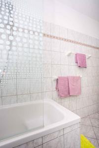 a white bathroom with a tub and pink towels at Apartment in Njivice/Insel Krk 13321 in Njivice