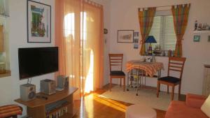 sala de estar con TV y mesa con sillas en Apartment in Malinska/Insel Krk 13156, en Malinska