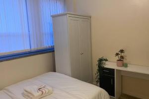 a bedroom with a bed with a towel on it at Luxury Home near Woolwich Arsenal Station in Woolwich