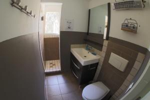 Un baño con lavabo, inodoro y espejo. en Chez Pierre à Porto-Vecchio, en Porto Vecchio 16 fotos más