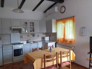 kuchnia ze stołem i krzesłami oraz kuchnia z białymi szafkami w obiekcie Holiday home in Rovinj - Istrien 11494 w Rovinj