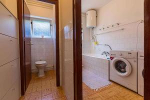 a bathroom with a toilet and a washing machine at Three-Bedroom Apartment in Crikvenica XIII in Sopaljska