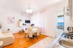 uma cozinha e sala de jantar com mesa e cadeiras em Two-Bedroom Apartment in Crikvenica XXXIII em Sopaljska