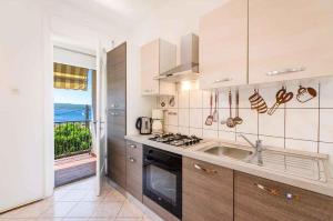 uma cozinha com um lavatório e um fogão forno superior em Two-Bedroom Apartment in Crikvenica XXXIII em Sopaljska