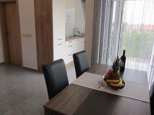 a dining room table with a pineapple and a bottle of wine at Two-Bedroom Apartment in Malinska/Insel Krk 13080 in Sveti Vid-Miholjice