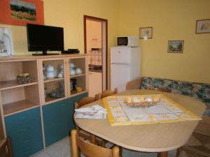a living room with a table and a tv and a kitchen at Apartments in Bibione 24604 in Bibione