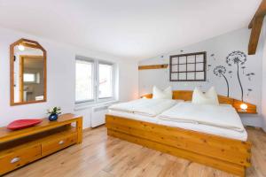 ein Schlafzimmer mit einem großen Holzbett und einem Spiegel in der Unterkunft Studio in Gross Kordshagen I in Arbshagen