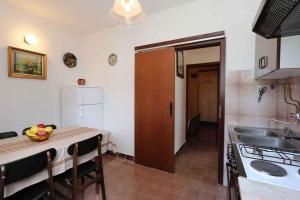 eine Küche mit einem Tisch mit einer Obstschale darauf in der Unterkunft Apartment in Silo - Insel Krk 13562 in Šilo