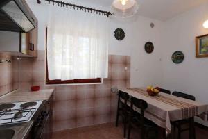 eine Küche mit einem Tisch mit Stühlen und einem Fenster in der Unterkunft Apartment in Silo - Insel Krk 13562 in Šilo