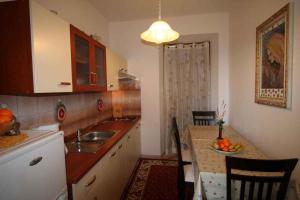a kitchen with a sink and a table with a bowl of fruit at Apartment in Silo/Insel Krk 13547 in Šilo