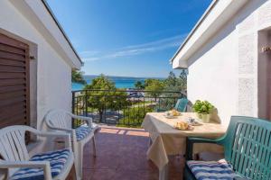 een tafel en stoelen op een balkon met uitzicht op de oceaan bij Apartment in Crikvenica 5600 in Crikvenica