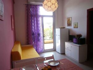 a kitchen with a table and a window with a refrigerator at Apartments in Bibione 24581 in Bibione