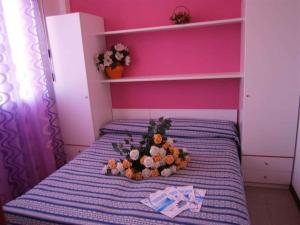 a flower arrangement on a bed in a pink room at Apartments in Bibione 24581 in Bibione