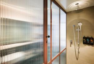 a shower with a glass door in a bathroom at Ovolo South Yarra in Melbourne