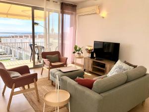 uma sala de estar com um sofá e uma televisão de ecrã plano em Fuseta Apartments - Bela Vista & Vista Mar - Penthouses em Fuzeta