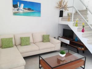 a living room with a couch and a table at Hermosa Casa Vacacional Puerto Morelos in Puerto Morelos