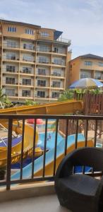 uma vista para uma piscina com escorrega e um hotel em Gold Coast Rose Studio em Banting