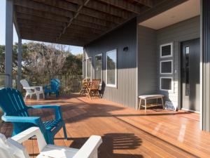 eine Terrasse mit Stühlen und Tischen auf einem Haus in der Unterkunft Coastal Luxury in Rye