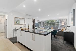 a kitchen and living room with a counter and a table at Central Location - Contemporary 2 Bedroom Aptm in Queenstown